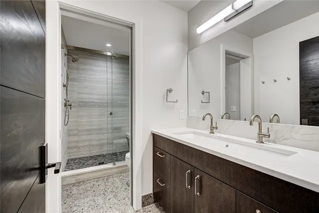 a bathroom with a sink a toilet and shower