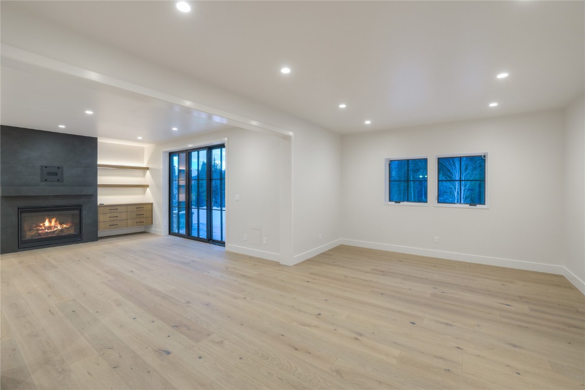 90 West Trade Court Keystone, CO 80435 - Photo 39 of 50 Unfurnished living room featuring light wood-style flooring, a large fireplace, and recessed lighting