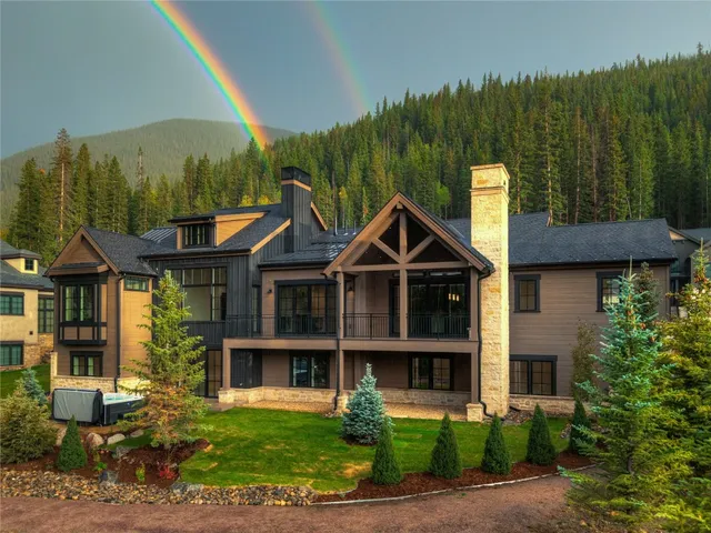 a view of a house with swimming pool and trees in the background