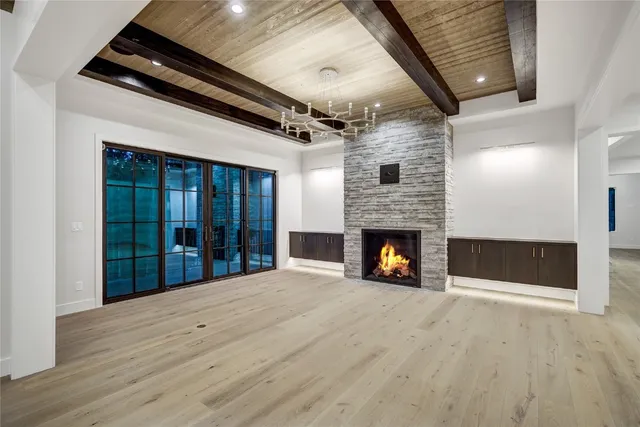 an empty room with a fireplace and wooden floor