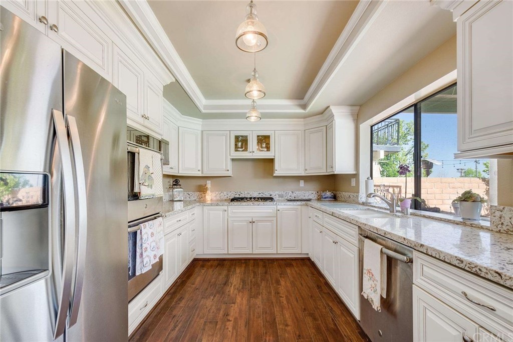 3750 Valley Lights Drive Pasadena, CA 91107 - Photo 20 of 55 a large kitchen with stainless steel appliances granite countertop a refrigerator a sink dishwasher a stove and white countertops with wooden floor
