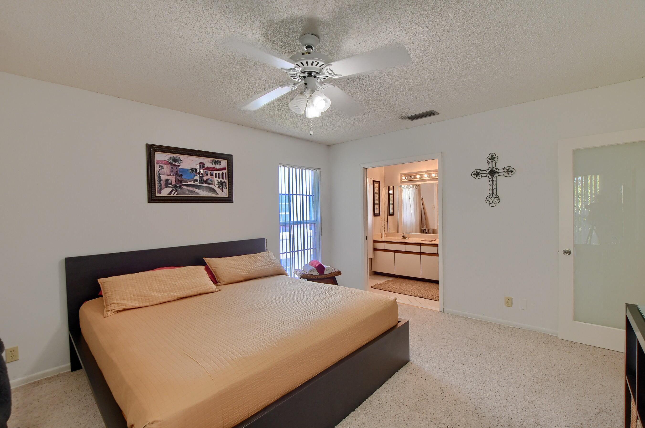 6237 Old Court Road, Unit 203 Boca Raton, FL 33433 - Photo 14 of 34 a bedroom with a large bed and a chandelier