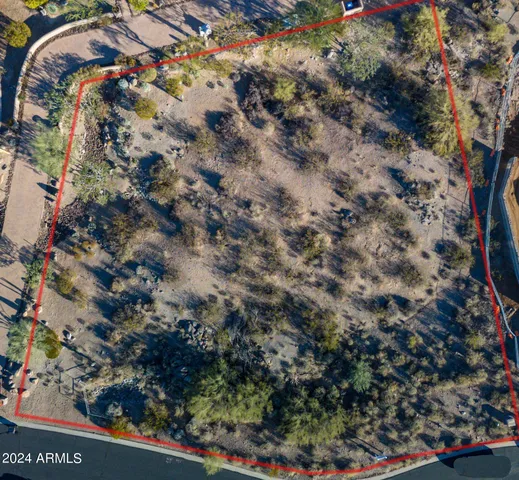 a view of a lush green field with mountains in the background