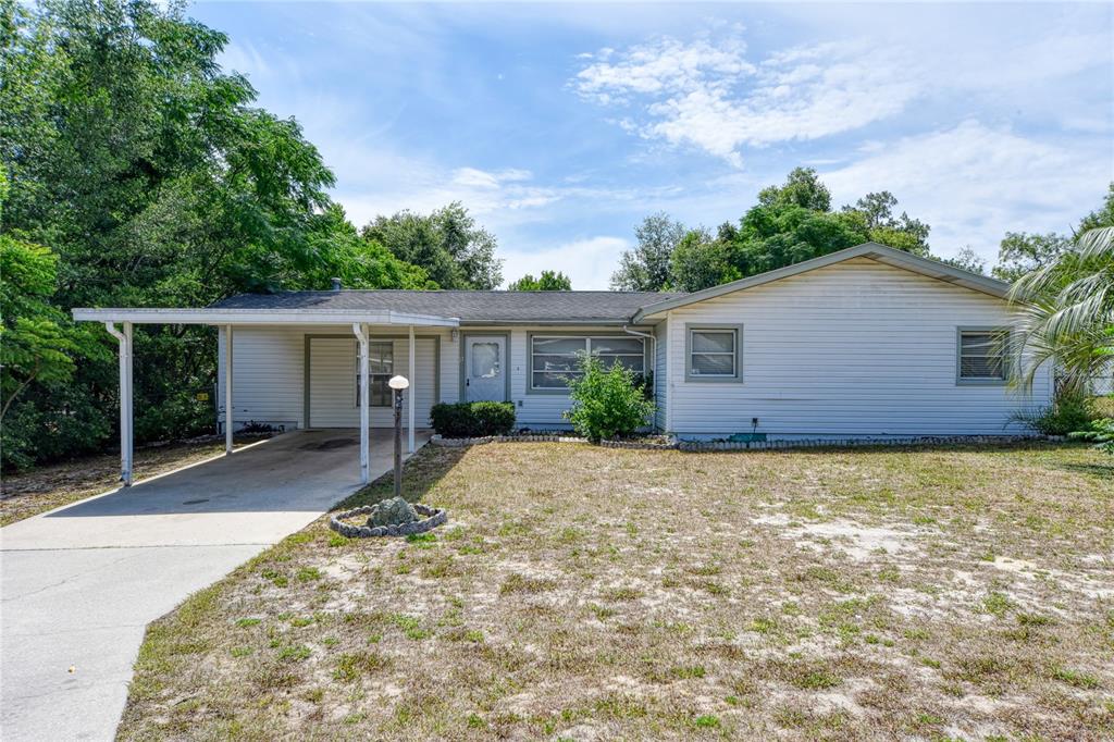 a front view of house with yard and trees around