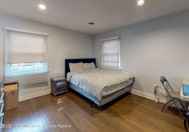 a bedroom with a bed and a dresser next to a window