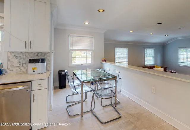 a kitchen with stainless steel appliances kitchen island granite countertop a stove a sink a refrigerator and white cabinets with wooden floor