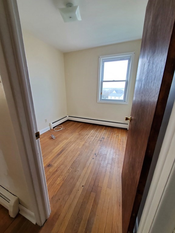 39 Beacon Street Fall River, MA 02721 - Photo 19 of 36 an empty room with wooden floor and windows