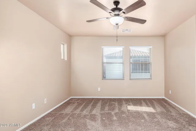 an empty room with fan and windows