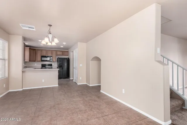 a view of a kitchen with a sink and dishwasher a refrigerator with white cabinets