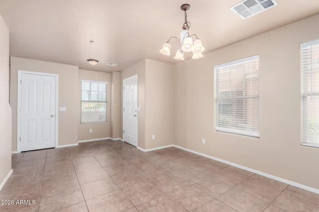 an empty room with chandelier and windows