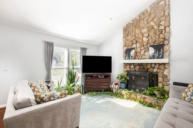 a living room with furniture a fireplace and a flat screen tv