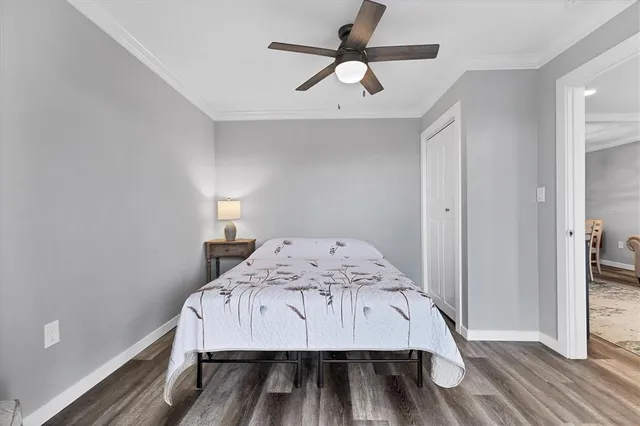 a view of a bedroom with wooden floor and a ceiling fan