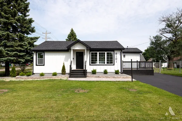 a front view of a house with a garden and trees