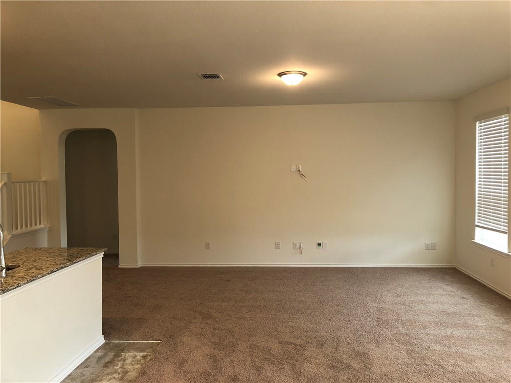 625 Jud Allen Way Leander, TX 78641 - Photo 9 of 18 Empty room featuring arched walkways and dark colored carpet
