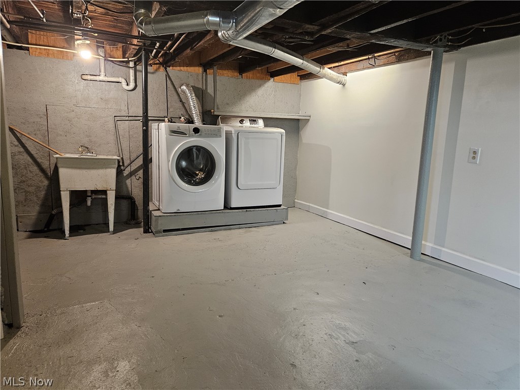 753 West River Road North Elyria, OH 44035 - Photo 17 of 28 Laundry area featuring a utility sink, painted concrete flooring, and exposed ceiling joists