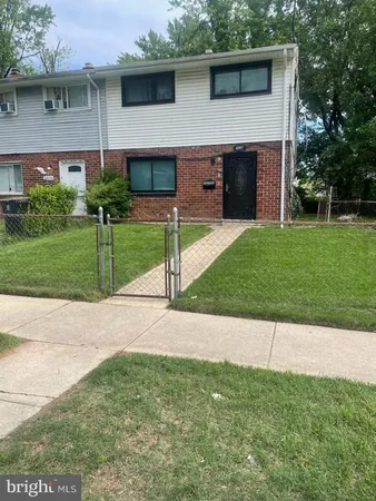 a view of a house with a yard and a large tree
