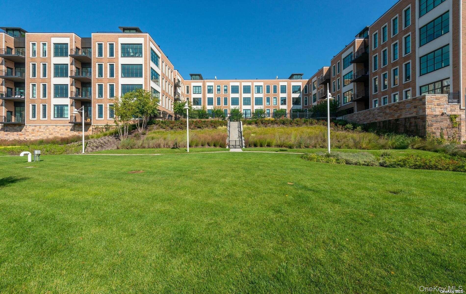 100 Garvies Point Road, Unit 1014 Glen Cove, NY 11542 - Photo 18 of 27 a view of a building with a yard