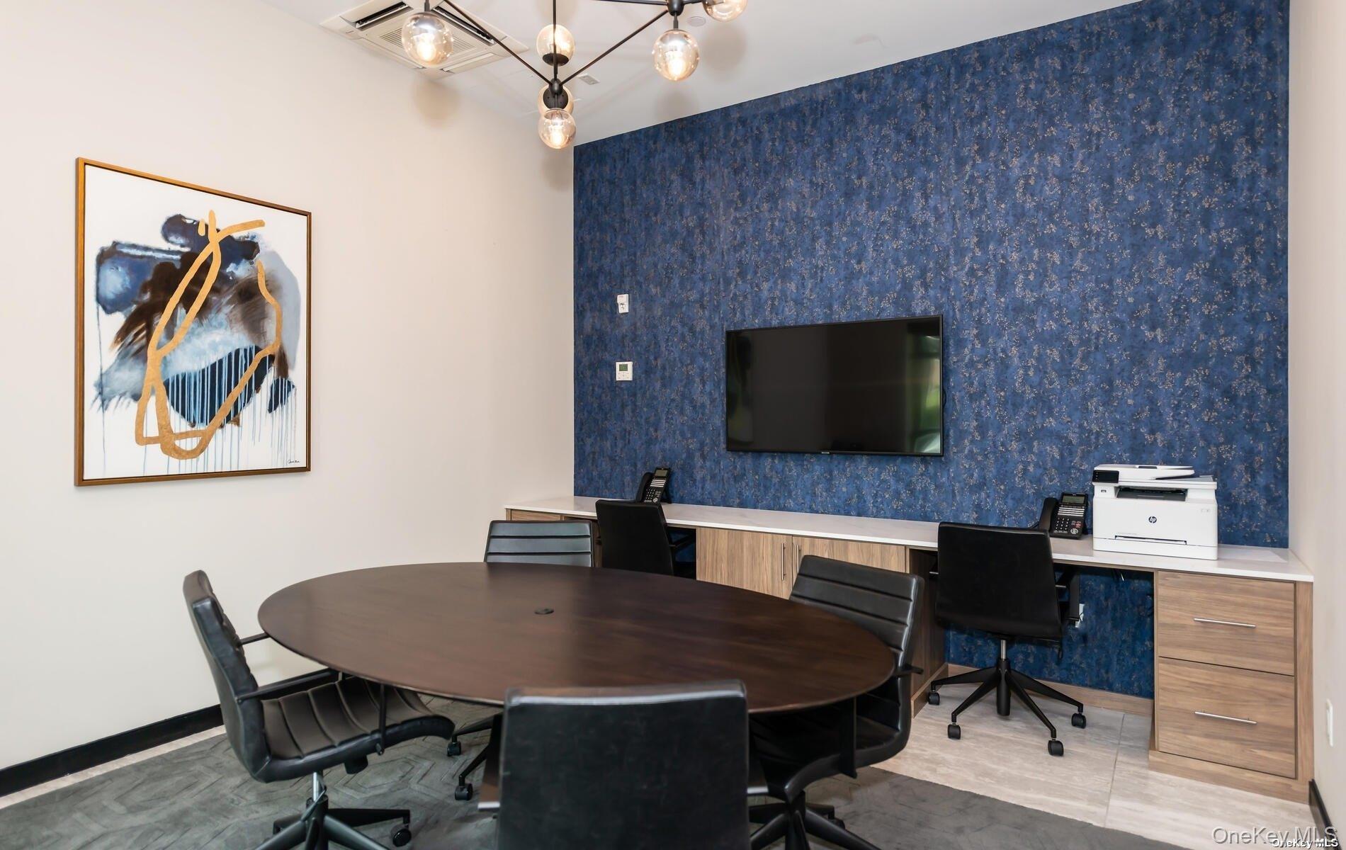 100 Garvies Point Road, Unit 1014 Glen Cove, NY 11542 - Photo 25 of 27 a workspace with furniture and a flat screen tv