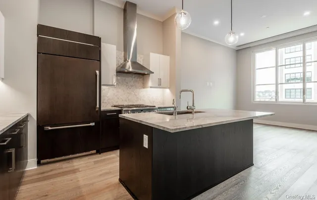 a kitchen with granite countertop a refrigerator and a sink