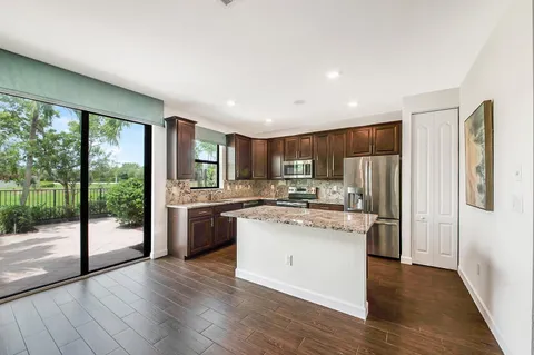 a living room with furniture kitchen and a wooden floor