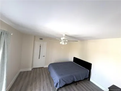 a spacious bedroom with a bed and wooden floor