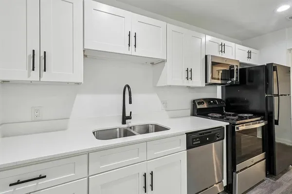 a view of a kitchen with a sink and stainless steel appliances