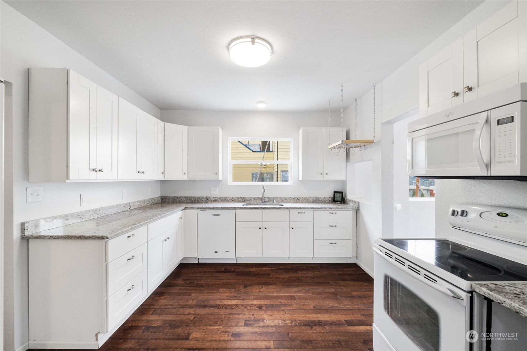 909 North 32nd Street Renton, WA 98056 - Photo 6 of 21 a kitchen with granite countertop white cabinets and white appliances
