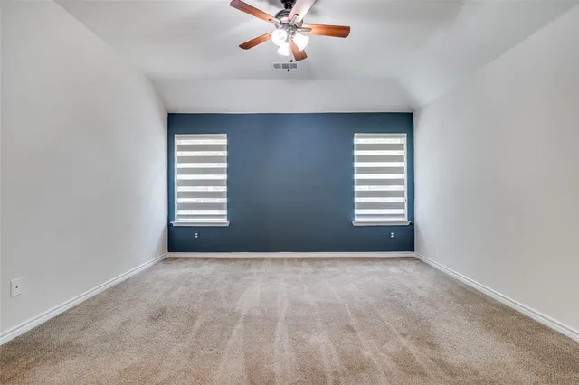 an empty room with windows and fan