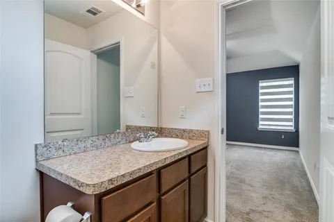 a bathroom with a granite countertop sink and a mirror