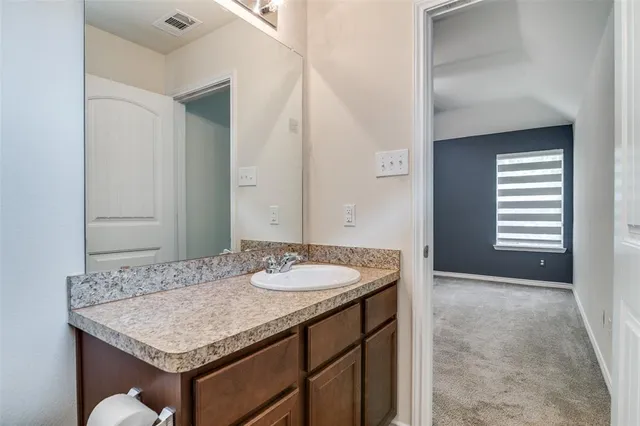 a bathroom with a granite countertop sink and a mirror