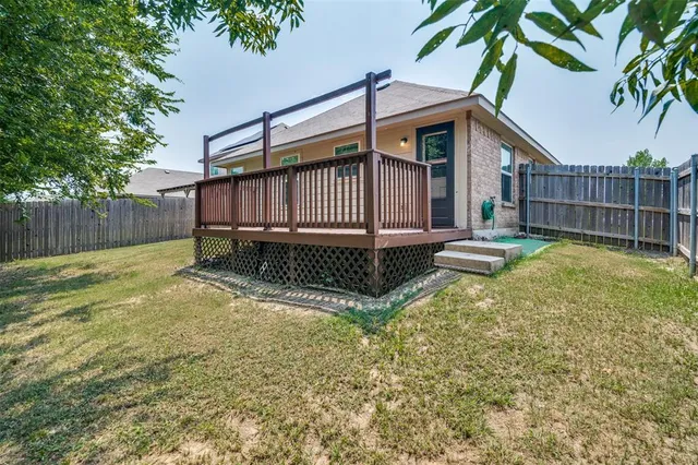 a view of a backyard with a small cabin and wooden fence