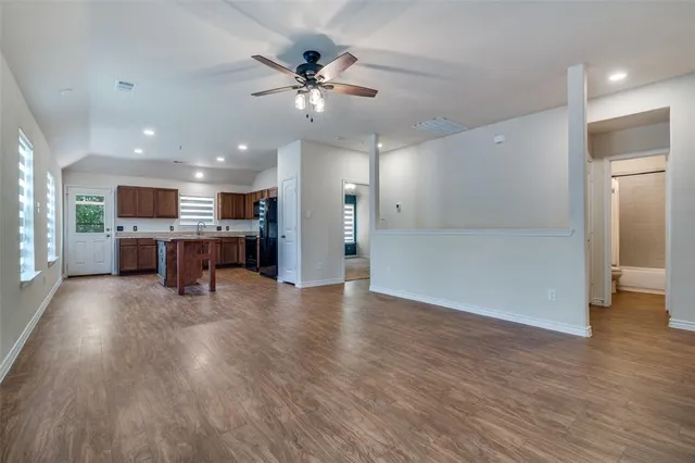 a view of a kitchen and a livingroom with furniture wooden floor kitchen view