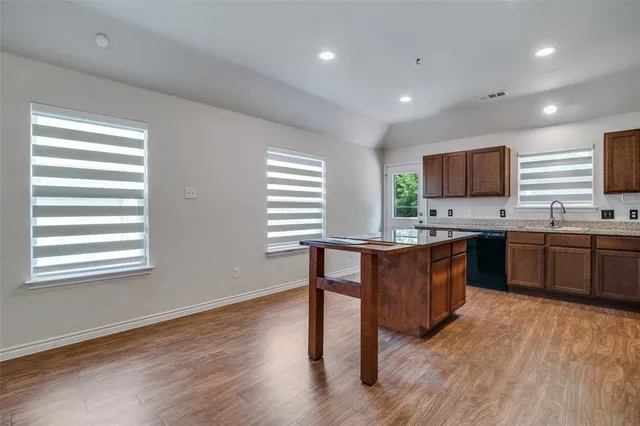 a kitchen with a sink cabinets and wooden floor