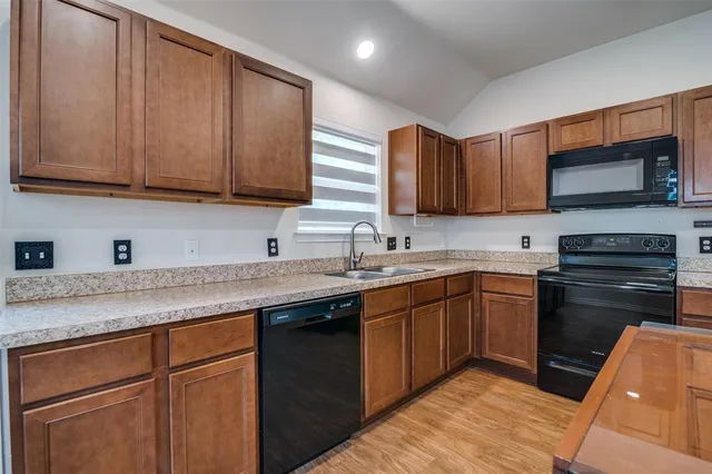 a kitchen with stainless steel appliances granite countertop wooden cabinets a sink and a stove