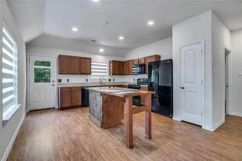 a kitchen with stainless steel appliances a microwave a stove a sink a refrigerator and cabinets