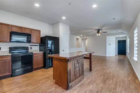 a kitchen with stainless steel appliances granite countertop a stove a sink and a refrigerator