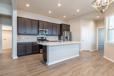 a kitchen with kitchen island granite countertop wooden floors and stainless steel appliances