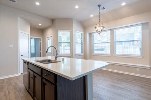 a kitchen with center island with wooden floor and large windows