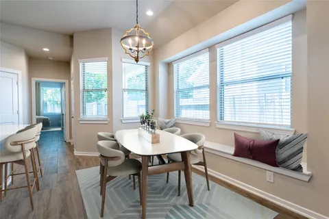 a view of a dining room with furniture a chandelier and wooden floor