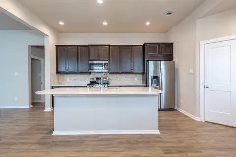 a large kitchen with cabinets and stainless steel appliances