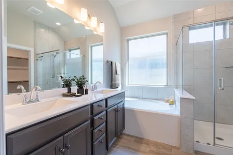 a bathroom with double vanity sinks and a bathtub