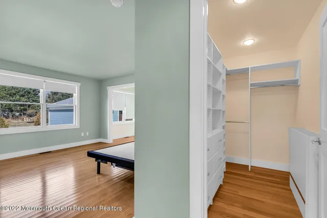 a view of a hallway with wooden floor and a living room