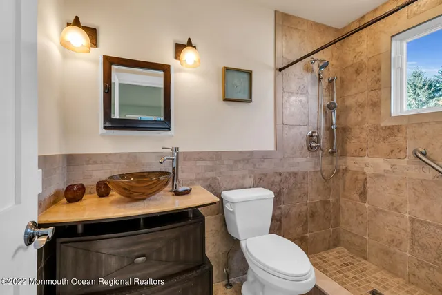 a bathroom with a toilet a sink and mirror