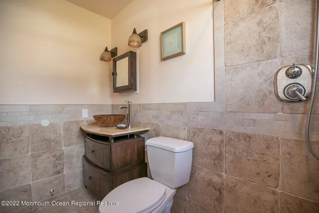 a bathroom with a toilet a sink and mirror