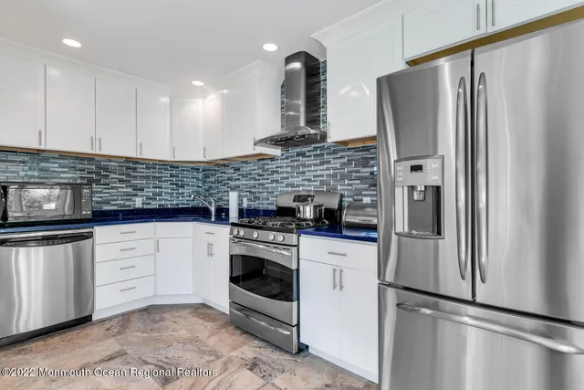 a kitchen with stainless steel appliances granite countertop a refrigerator sink and stove
