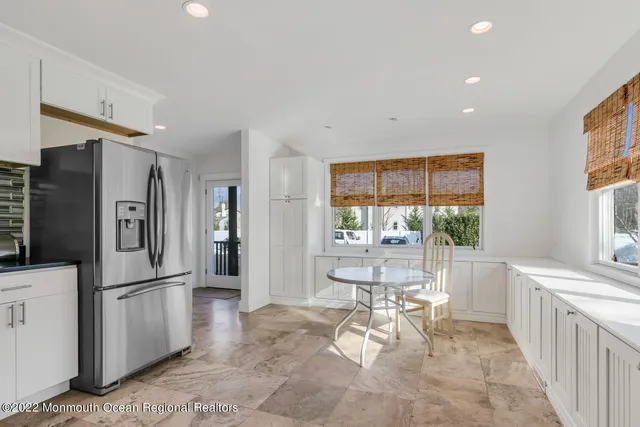 a living room with furniture a large window and stainless steel appliances