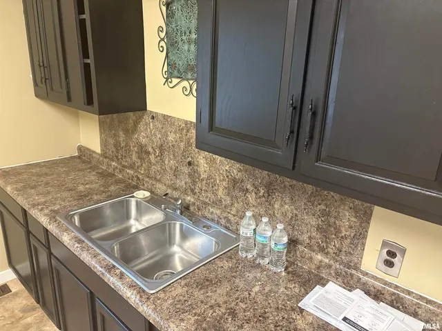 a kitchen with granite countertop a sink and cabinets