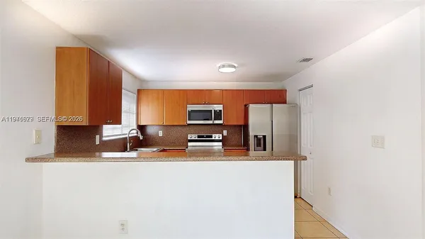 a kitchen with stainless steel appliances granite countertop a sink stove and microwave