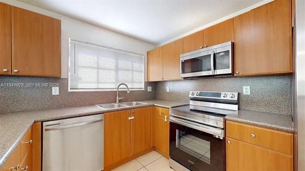 a kitchen with stainless steel appliances granite countertop a stove microwave and refrigerator