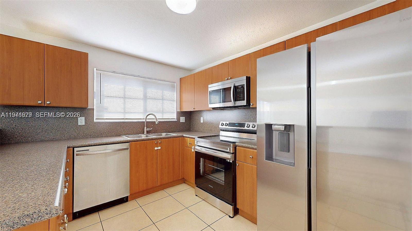 14162 Southwest 260th Street, Unit 104 Homestead, FL 33032 - Photo 2 of 35 a kitchen with stainless steel appliances granite countertop a stove top oven a sink and dishwasher